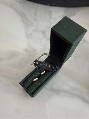 SHASHI Gold Crystal Bar Stud Earrings in Dark Green Box